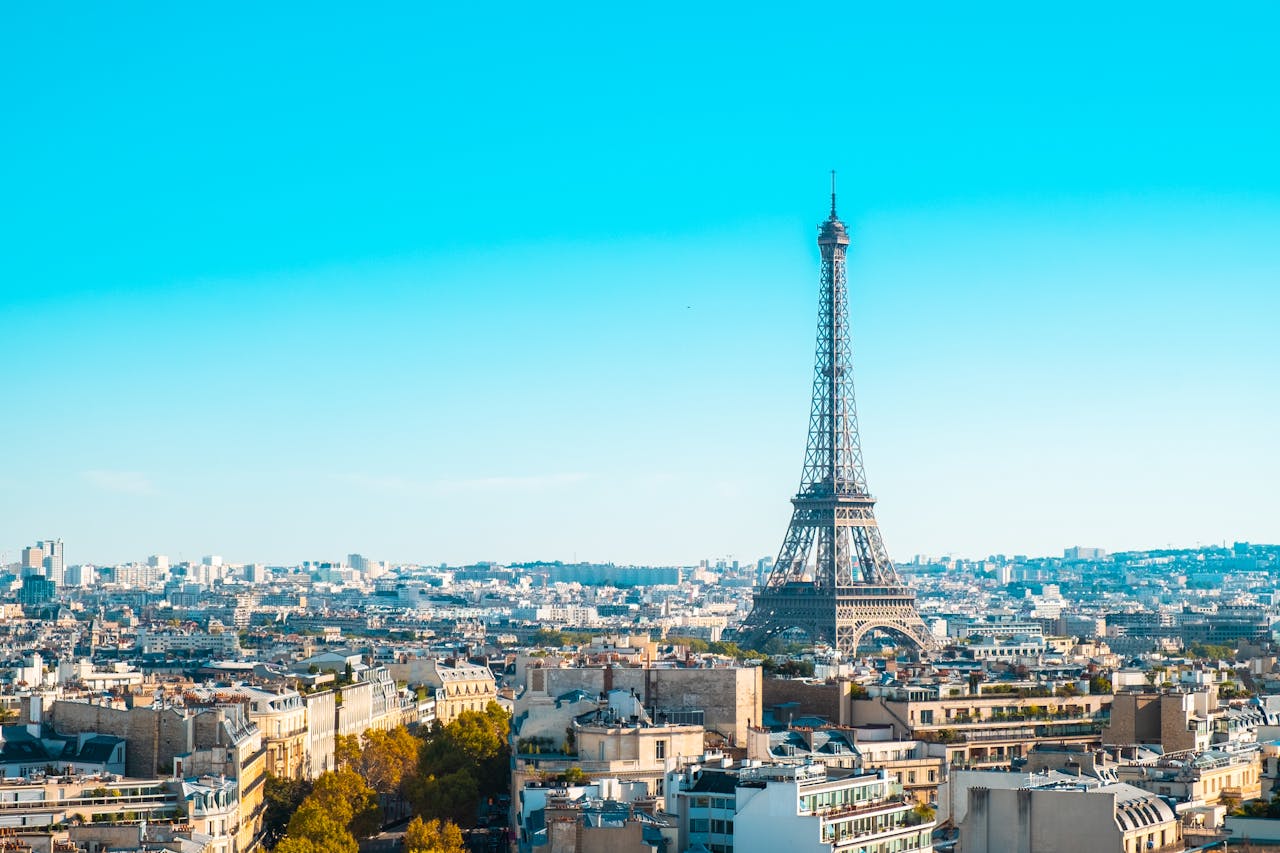 Eiffel Tower overlooking the cityscape of Paris under clear blue skies.