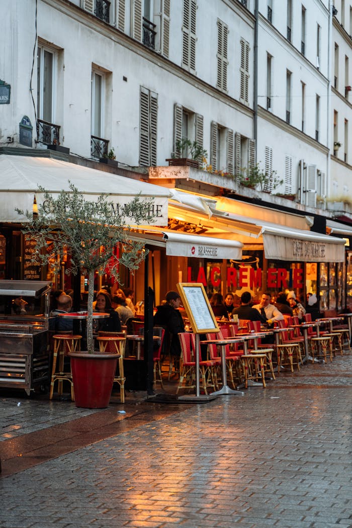 Discover the vibrant atmosphere of a Parisian café bustling with life in the evening light.